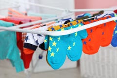 Olika färgrika sockor på att torka kuggen mot suddig bakgrund arkivfoto Olika färgrika sockor på att torka kuggen mot suddig bakgrund arkivfoto