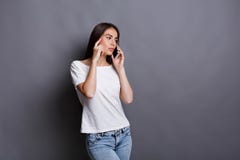 Olycklig ung kvinna som använder smartphoneståenden arkivfoto Olycklig ung kvinna som använder smartphoneståenden arkivfoto