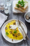 Omelette with truffle and parsley, served with sour cream, bread and a glass of fresh water. royalty free stock image Omelette with truffle and parsley, served with sour cream, bread and a glass of fresh water. royalty free stock image