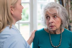 Omsorgarbetare som hemma talar till den deprimerade höga kvinnan royaltyfri foto Omsorgarbetare som hemma talar till den deprimerade höga kvinnan royaltyfri foto
