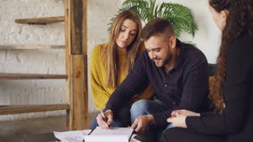 Ondertekent de knappe mens van de huiskoper verkoopovereenkomst met het huisvesten van agent, het worden zeer belangrijk en daarn stock footage Ondertekent de knappe mens van de huiskoper verkoopovereenkomst met het huisvesten van agent, het worden zeer belangrijk en daarn stock footage