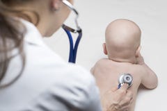 One caucasian female doctor is listening heartbeat of infant boy by stethoscope Royalty Free Stock Image One caucasian female doctor is listening heartbeat of infant boy by stethoscope Royalty Free Stock Image