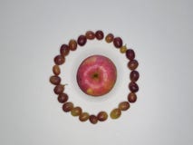 One fresh Apple surrounded by grapes on white background top view stock images One fresh Apple surrounded by grapes on white background top view stock images