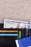 One hundred dollars banknote reach out out of a black old purse. Stock Image One hundred dollars banknote reach out out of a black old purse. Stock Image