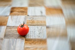 One organic red tomat on surface mosaik board with pieces of different breeds as chess board background. Selective focus stock photos One organic red tomat on surface mosaik board with pieces of different breeds as chess board background. Selective focus stock photos