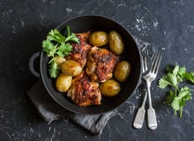 One pot baked harissa chicken and new potatoes on a dark background royalty free stock photography One pot baked harissa chicken and new potatoes on a dark background royalty free stock photography