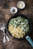 One pot creamy chicken spinach and green peas farfalle pasta in the pan on brown wooden background Stock Photos One pot creamy chicken spinach and green peas farfalle pasta in the pan on brown wooden background Stock Photos