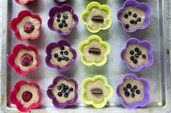 Ongebakken banaanmuffins met chocoladerepen, bosbessen, aardbeien, noten en rozijnen in de vormen van het kleurensilicone royalty-vrije stock afbeelding Ongebakken banaanmuffins met chocoladerepen, bosbessen, aardbeien, noten en rozijnen in de vormen van het kleurensilicone royalty-vrije stock afbeelding