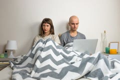 Ongelukkig of ontevreden jong paar in bed royalty-vrije stock afbeeldingen Ongelukkig of ontevreden jong paar in bed royalty-vrije stock afbeeldingen