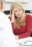 Ongerust gemaakte Rijpe Vrouwenvergadering met Arts In Surgery stock afbeelding Ongerust gemaakte Rijpe Vrouwenvergadering met Arts In Surgery stock afbeelding