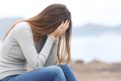 Ongerust gemaakte tienervrouw op het strand in de winter