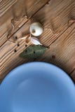 Onion, garlic, black pepper and bay leaf with empty blue plate on a wooden background stock images Onion, garlic, black pepper and bay leaf with empty blue plate on a wooden background stock images