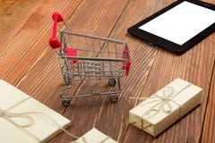 Online-shoppingbegrepp - PC för tom shoppingvagn, bärbar dator- och minnestavla, gåvaask på lantlig träbakgrund arkivbilder Online-shoppingbegrepp - PC för tom shoppingvagn, bärbar dator- och minnestavla, gåvaask på lantlig träbakgrund arkivbilder