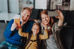 Ono uśmiecha się rodzice z chłopiec biorą selfie przy lotniskiem obraz royalty free Ono uśmiecha się rodzice z chłopiec biorą selfie przy lotniskiem obraz royalty free