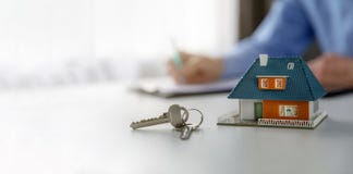 Onroerende goederenbedrijfsconcept - het model en de sleutels van de nieuw huisschaal op de lijst op makelaar in onroerend goedka royalty-vrije stock afbeeldingen Onroerende goederenbedrijfsconcept - het model en de sleutels van de nieuw huisschaal op de lijst op makelaar in onroerend goedka royalty-vrije stock afbeeldingen
