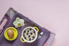 Ontbijt in bed hoogste mening over een dienblad van havermeel in een gele pot, muesli met verse bosbessen, ei op een purper serve royalty-vrije stock foto's Ontbijt in bed hoogste mening over een dienblad van havermeel in een gele pot, muesli met verse bosbessen, ei op een purper serve royalty-vrije stock foto's