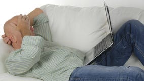 Ontspannen Zakenman Staying op de Laag in het Leven en het Werk die Laptop met behulp van royalty-vrije stock foto Ontspannen Zakenman Staying op de Laag in het Leven en het Werk die Laptop met behulp van royalty-vrije stock foto