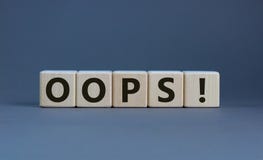 Oops sign on wooden cubes. Beautiful grey background, copy space. Concept