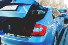 Open boomstam van de blauwe auto waarin de extra kindzetel wordt opgeslagen royalty-vrije stock afbeelding Open boomstam van de blauwe auto waarin de extra kindzetel wordt opgeslagen royalty-vrije stock afbeelding