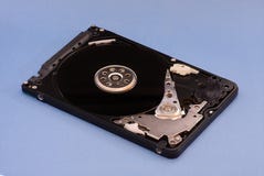 Opened демонтировало жесткий диск от компьютера, hdd с влиянием зеркала На голубой предпосылке стоковая фотография rf Opened демонтировало жесткий диск от компьютера, hdd с влиянием зеркала На голубой предпосылке стоковая фотография rf