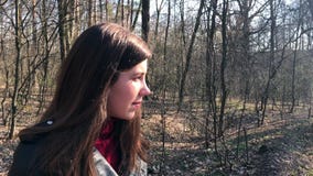 Openluchtportret van jong mooi Kaukasisch tienermeisje die en camera, bosweg op een winderige dag glimlachen onderzoeken stock video Openluchtportret van jong mooi Kaukasisch tienermeisje die en camera, bosweg op een winderige dag glimlachen onderzoeken stock video