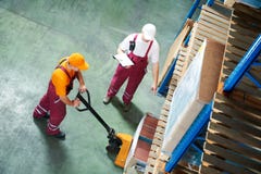 Operaio con il camion di pallet della forcella Immagini Stock Libere da Diritti Operaio con il camion di pallet della forcella Immagini Stock Libere da Diritti