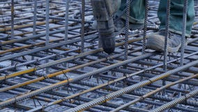 Operaio di costruzione Lavoratore nel cantiere che fa la struttura del metallo di rinforzo per il versamento concreto fotografia stock libera da diritti Operaio di costruzione Lavoratore nel cantiere che fa la struttura del metallo di rinforzo per il versamento concreto fotografia stock libera da diritti