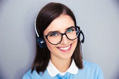 Operatore femminile sorridente con la cuffia avricolare del telefono fotografia stock Operatore femminile sorridente con la cuffia avricolare del telefono fotografia stock
