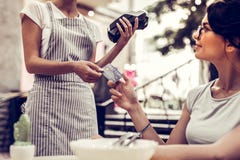 Opgetogen aardige vrouw die haar debetkaart geven stock afbeelding Opgetogen aardige vrouw die haar debetkaart geven stock afbeelding