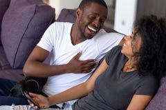 Opgewekt Afrikaans Amerikaans paar die bij grappige grap samen lachen stock foto Opgewekt Afrikaans Amerikaans paar die bij grappige grap samen lachen stock foto