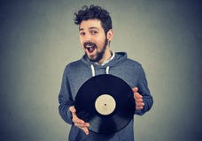 Opgewekte hipster mens die met vinylverslag camera bekijken royalty-vrije stock afbeeldingen Opgewekte hipster mens die met vinylverslag camera bekijken royalty-vrije stock afbeeldingen