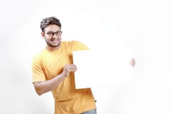 Opgewekte Jonge Indische mens op bril en ter beschikking het tonen van lege affiche stock fotografie Opgewekte Jonge Indische mens op bril en ter beschikking het tonen van lege affiche stock fotografie