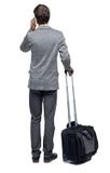 Opini?o traseira o homem de neg?cio com mala de viagem que fala no telefone fotos de stock Opini?o traseira o homem de neg?cio com mala de viagem que fala no telefone fotos de stock