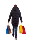 Opini?o traseira o homem no revestimento do inverno com sacos de compras imagem de stock Opini?o traseira o homem no revestimento do inverno com sacos de compras imagem de stock