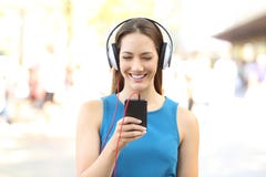 Opinião dianteira uma menina que escuta a música na rua imagem de stock Opinião dianteira uma menina que escuta a música na rua imagem de stock