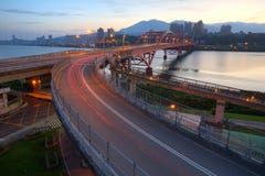 A opinião do amanhecer do carro arrasta em uma ponte curvada da estrada sobre o rio bonito de Tamsui na cidade de Taipei, Taiwan fotos de stock royalty free A opinião do amanhecer do carro arrasta em uma ponte curvada da estrada sobre o rio bonito de Tamsui na cidade de Taipei, Taiwan fotos de stock royalty free