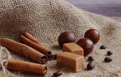 A opinião do close-up das varas de canela amarradas com corda, os chocolates e os feijões de café estão encontrando-se em um guar foto de stock A opinião do close-up das varas de canela amarradas com corda, os chocolates e os feijões de café estão encontrando-se em um guar foto de stock