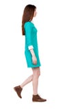 Opinião lateral a mulher de passeio no vestido imagens de stock royalty free Opinião lateral a mulher de passeio no vestido imagens de stock royalty free