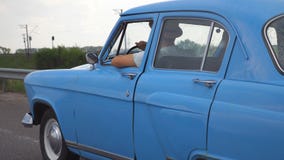 Opinião lateral o homem irreconhecível nos chapéus que conduzem no carro retro azul após a chuva durante o curso do verão Indivíd video estoque Opinião lateral o homem irreconhecível nos chapéus que conduzem no carro retro azul após a chuva durante o curso do verão Indivíd video estoque