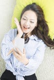 A opinião superior a mulher asiática toma um selfie e o encontro no assoalho na sala de visitas foto de stock A opinião superior a mulher asiática toma um selfie e o encontro no assoalho na sala de visitas foto de stock