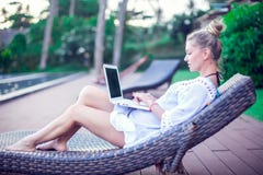 Opinião traseira a jovem mulher que faz o trabalho remoto no whil moderno do portátil imagens de stock royalty free Opinião traseira a jovem mulher que faz o trabalho remoto no whil moderno do portátil imagens de stock royalty free
