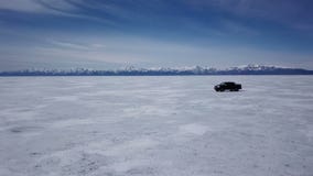 Opinión aérea del abejón del coche en paisaje del invierno y hola velocidad que conduce sobre el lago congelado metrajes Opinión aérea del abejón del coche en paisaje del invierno y hola velocidad que conduce sobre el lago congelado metrajes