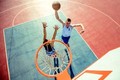 Opinión de alto ángulo del baloncesto dunking del jugador de básquet en aro imagen de archivo Opinión de alto ángulo del baloncesto dunking del jugador de básquet en aro imagen de archivo