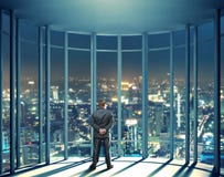 Opinión de la noche edificios y el hombre de la ventana de cristal foto de archivo libre de regalías Opinión de la noche edificios y el hombre de la ventana de cristal foto de archivo libre de regalías