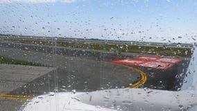 Opinión de la pista del aeropuerto con la mudanza de la ventana plana antes de la salida con gotas de lluvia almacen de metraje de vídeo Opinión de la pista del aeropuerto con la mudanza de la ventana plana antes de la salida con gotas de lluvia almacen de metraje de vídeo