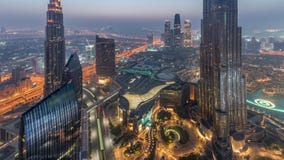 Opinión del horizonte de Paniramic del centro de la ciudad de Dubai con la alameda, las fuentes y la noche aérea de Burj Khalifa almacen de metraje de vídeo Opinión del horizonte de Paniramic del centro de la ciudad de Dubai con la alameda, las fuentes y la noche aérea de Burj Khalifa almacen de metraje de vídeo