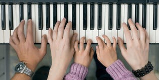 Opinión superior del teclado de piano y manos de la madre y del padre del niño Foto de archivo Opinión superior del teclado de piano y manos de la madre y del padre del niño Foto de archivo