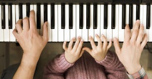 Opinión superior del teclado de piano y manos de la madre y del padre del niño Fotografía de archivo Opinión superior del teclado de piano y manos de la madre y del padre del niño Fotografía de archivo