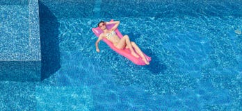 Opinión superior la mujer que broncea hermosa en piscina imagen de archivo Opinión superior la mujer que broncea hermosa en piscina imagen de archivo