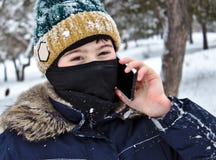 Opowiadać na telefon chłopiec w trykotowym kapeluszu z balaclava i dymienicą zdjęcia royalty free Opowiadać na telefon chłopiec w trykotowym kapeluszu z balaclava i dymienicą zdjęcia royalty free